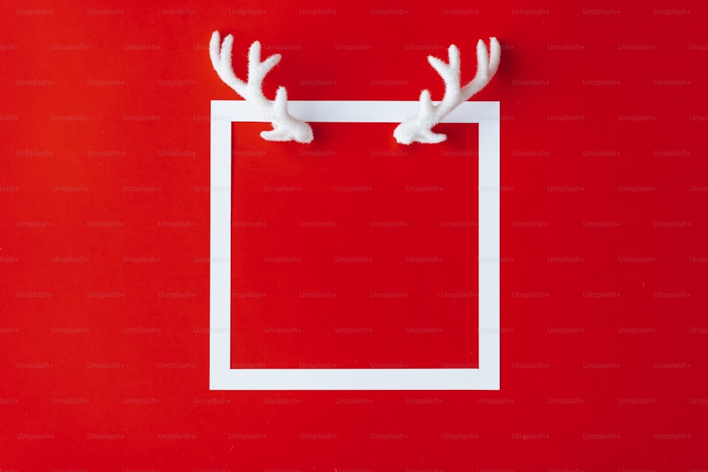 Reindeer antlers with white frame on red background.