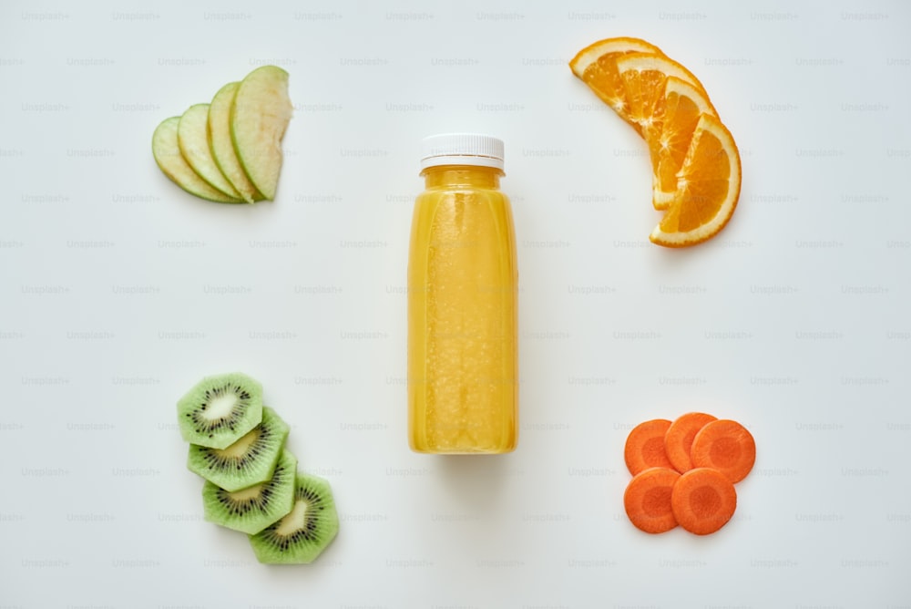 Kalorienarme Nahrung. Frischer Orangen-Smoothie mit isolierten Früchten auf weißem Hintergrund. Orange, Äpfel, Karotten und Kiwi