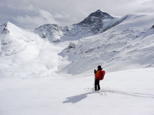eine Backcountry-Skifahrerin auf einem hochalpinen Gletscher in den österreichischen Alpen im Winter unter blauem Himmel