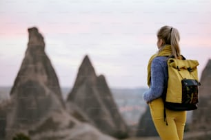 Viajar. Mulher que viaja na natureza com mochila. Menina no Vale das Pedras na Turquia. Alta Resolução