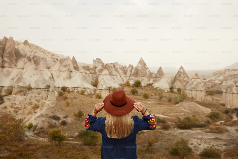 As pessoas viajam. Bela mulher no chapéu viajando no Rock Valley, explorando a paisagem da natureza. Alta Resolução