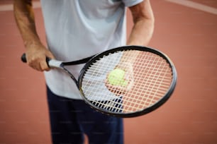 Moderner Tennisspieler, der Schläger und Ball hält, während er im Stadion steht
