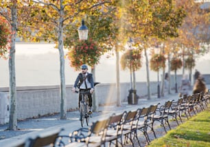 Empresário hipster com bicicleta viajando para casa do trabalho na cidade ao pôr do sol. Espaço de cópia.