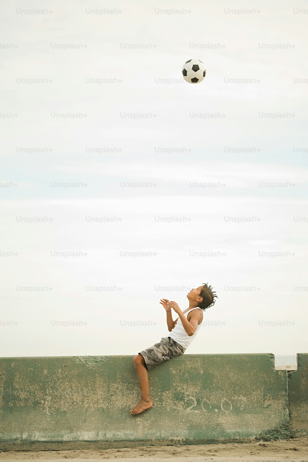 a young boy is playing with a soccer ball