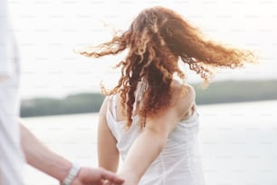 Beautiful girl holding her boyfriend's hand. Summer season