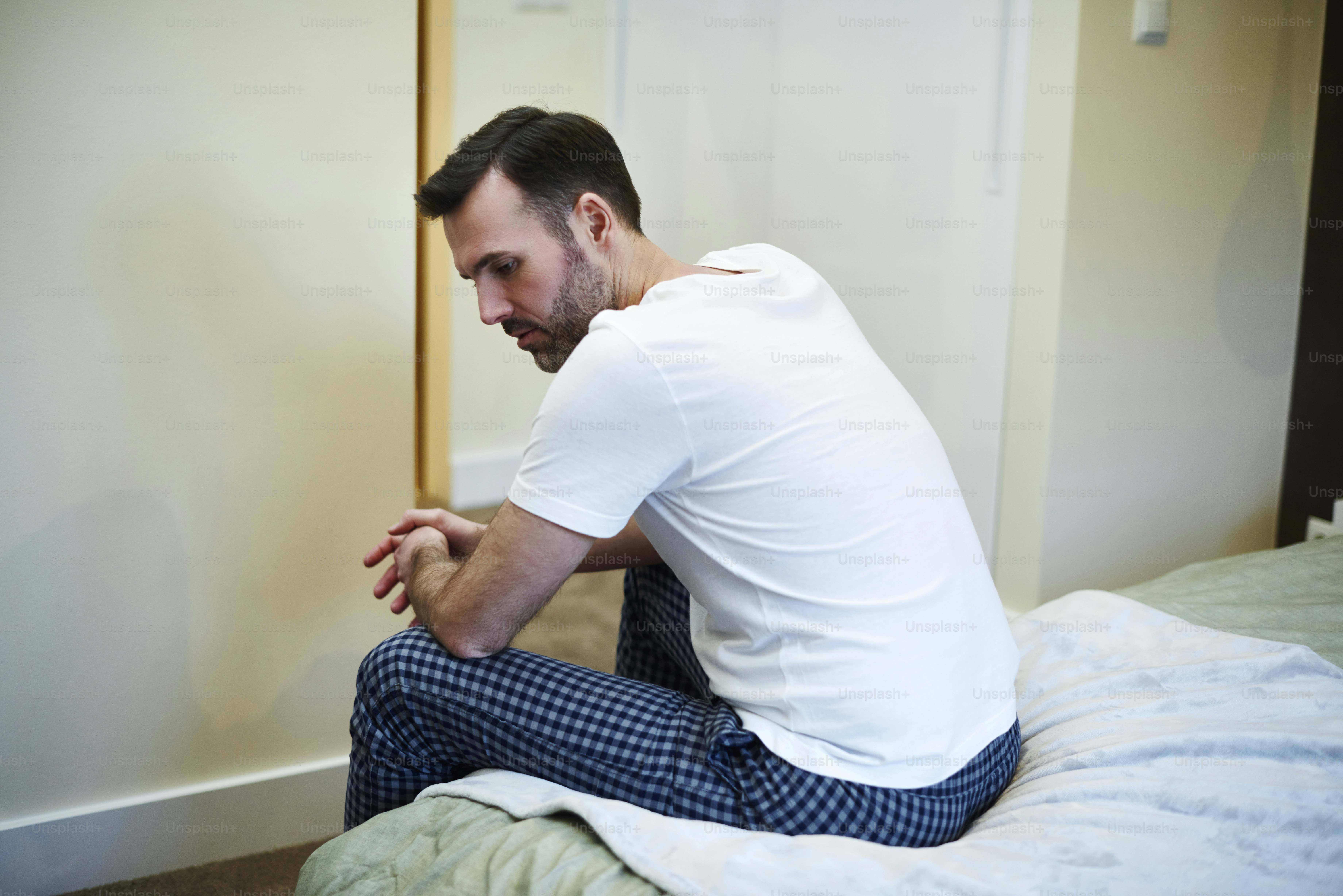Uomo preoccupato seduto sul letto