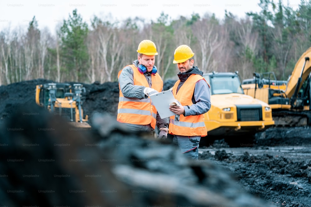 Workers in quarry looking at a plan on clipboard