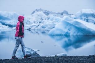 La viaggiatrice viaggia a Jokulsarlon, bellissima laguna glaciale in Islanda. Jokulsarlon è una famosa destinazione nel Parco Nazionale di Vatnajokull, nel sud-est dell'Islanda, in Europa. Freddo inverno ghiaccio natura.