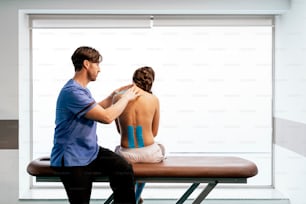 Fisioterapeuta dando terapia de ombro a uma mulher na clínica. Conceito de tratamento físico