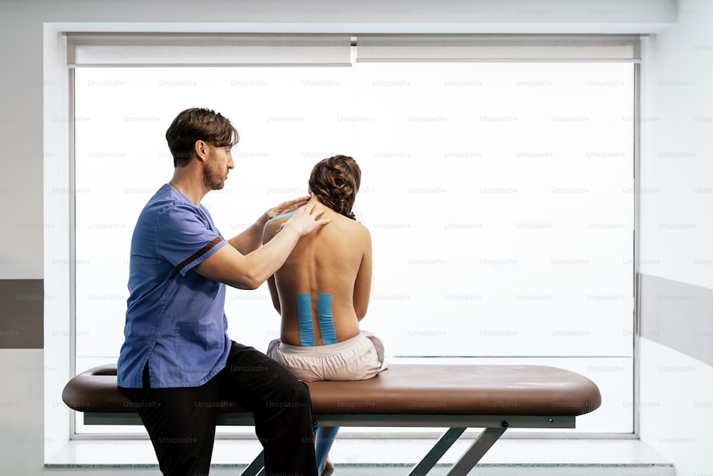 Physiotherapist giving shoulder therapy to a woman in clinic. Physical treatment concept