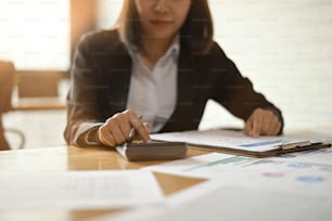 Accounting Financial businesswoman working with calculator and finance report.