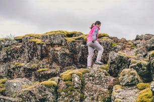 Mulher viajante e exploradora viaja na paisagem islandesa caminhando pela Islândia para descobrir a natureza única no verão.
