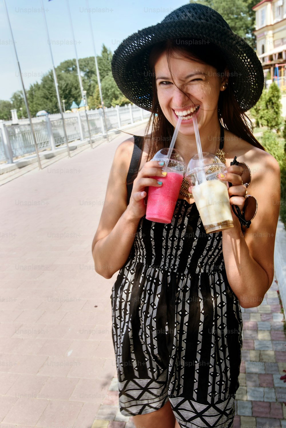 feliz mulher elegante hipster segurando coquetéis coloridos e se divertindo, conceito de viagem de verão