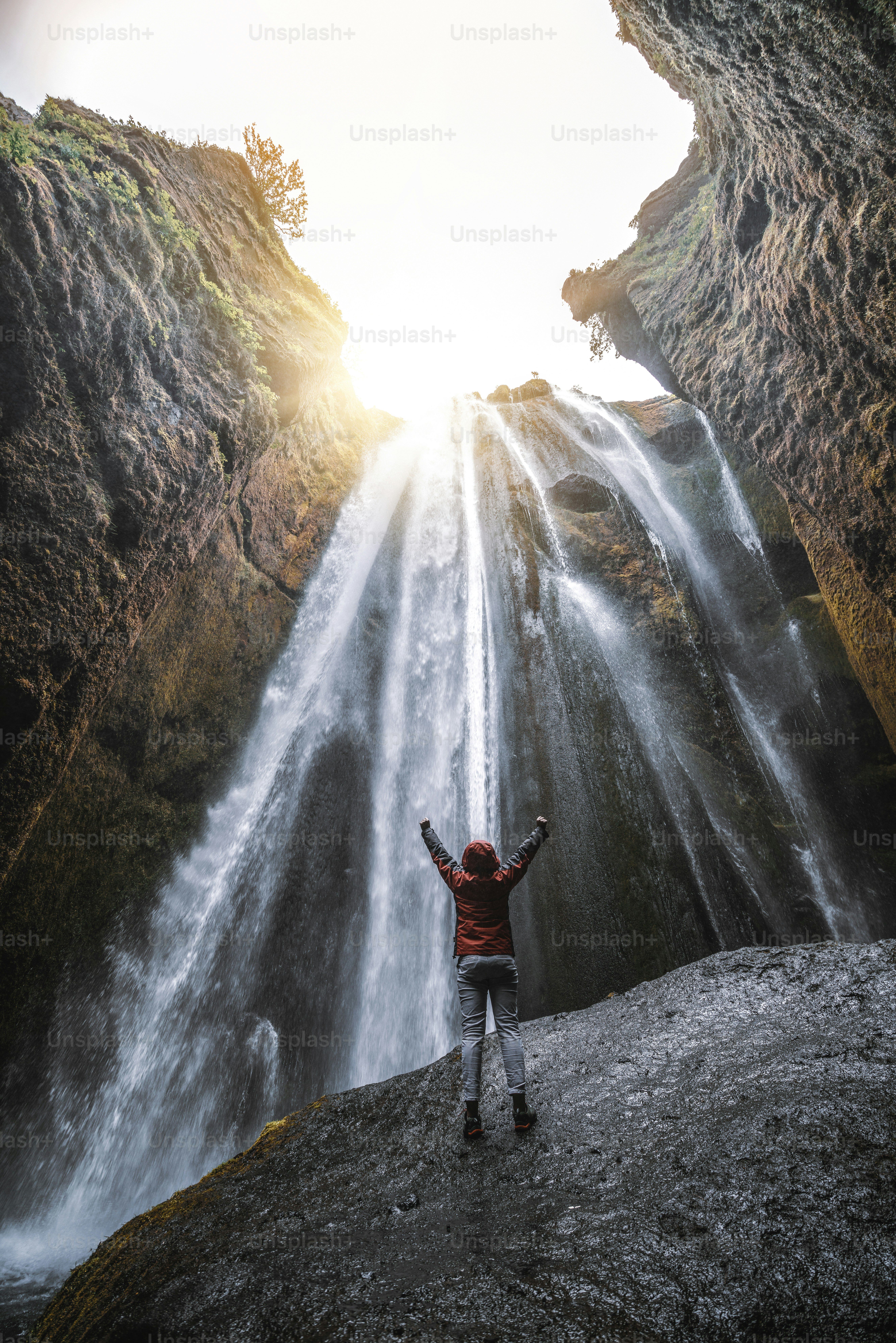 Traveler stunned by Gljufrabui waterfall cascade in Iceland. Located at scenic Seljalandsfoss waterfall South of Iceland, Europe. It is top beautiful destination of popular tourist travel attraction.
