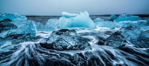 アイスランドのダイヤモンドビーチの氷山。アイスランド南東部、ヴァトナヨークトル国立公園のヨークルスアゥルロゥルの美しい氷河湖から流れ出るダイヤモンドビーチとして知られる黒い砂浜の凍った氷。