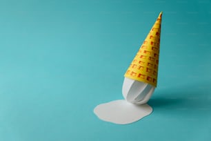 Melted paper vanilla ice-cream cone on blue background. Copy space. Creative or art food concept