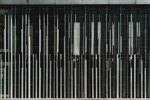 A frontal view of an abstract metal contemporary building facade with striped iron vertical blocks of different form and thickness; view of an outdoor exterior of a modern house with an odd texture
