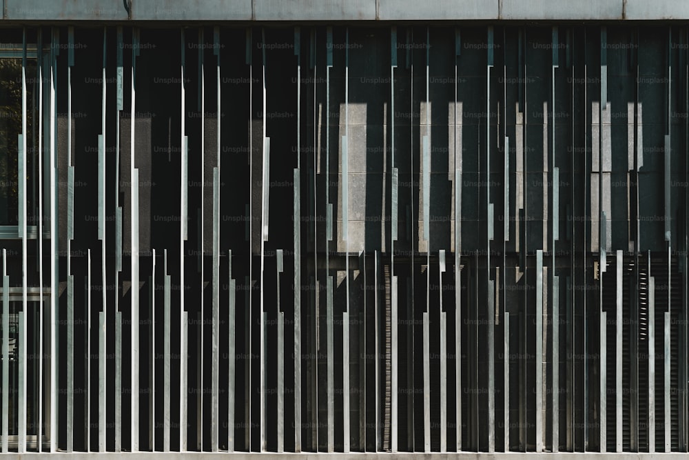 Una vista frontal de una fachada de edificio contemporáneo de metal abstracto con bloques verticales de hierro rayado de diferente forma y grosor; Vista de un exterior exterior de una casa moderna con una textura extraña