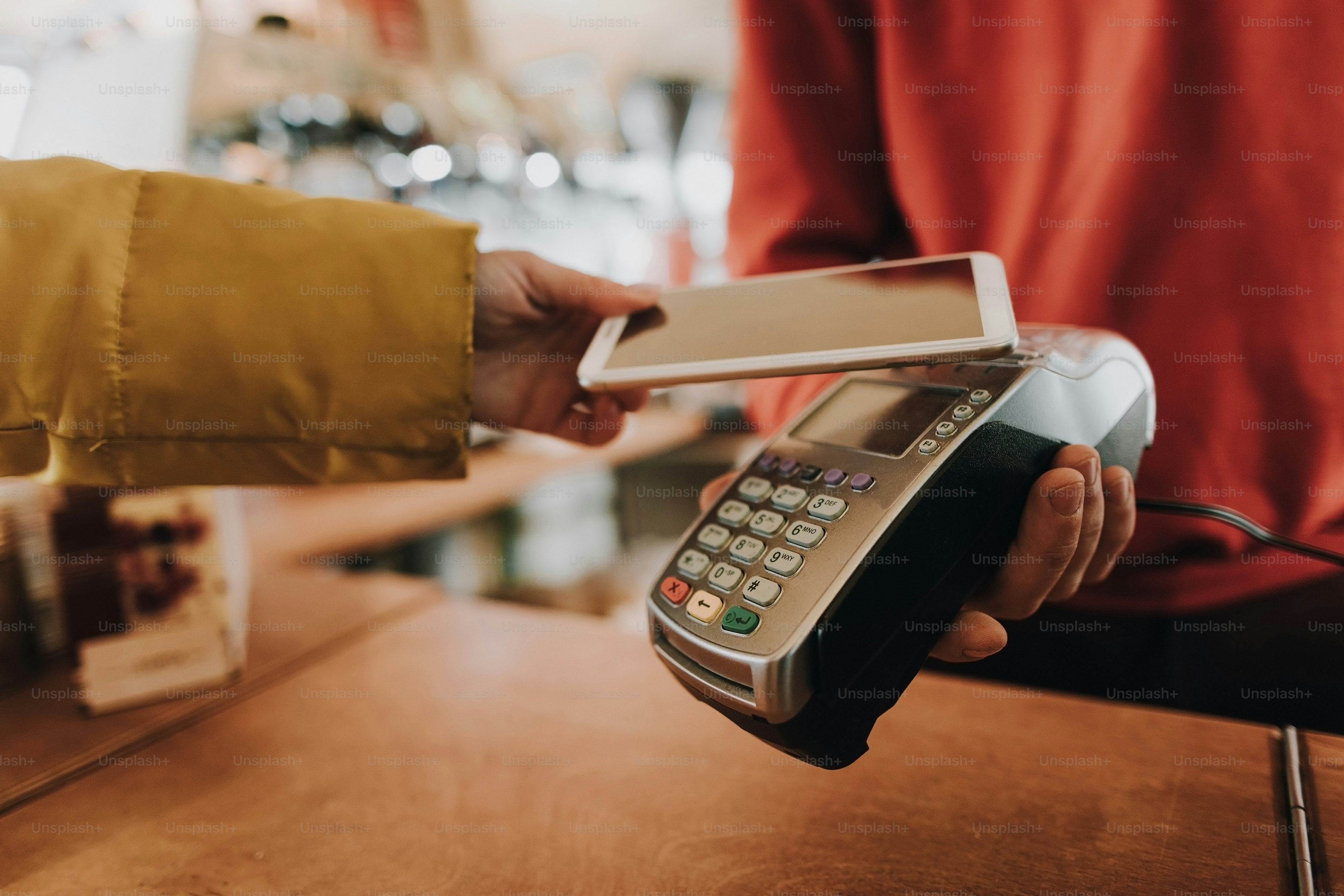 Card payments. Close up portrait of young woman in overclothes paying the bill in cafe via contactless payments in mobile phone