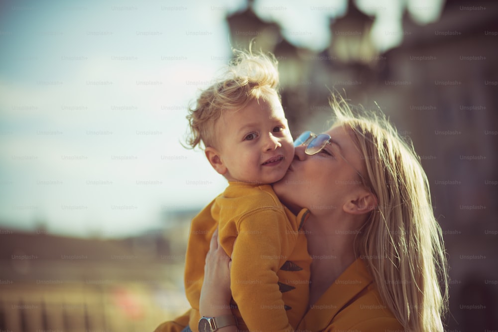 She love to kiss him. Mother and son in the city.