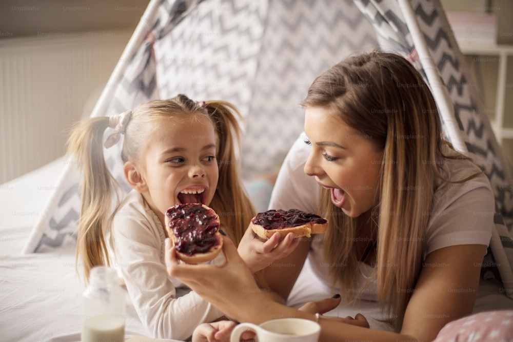 Delicious.  Mother and daughter having breakfast in bed.