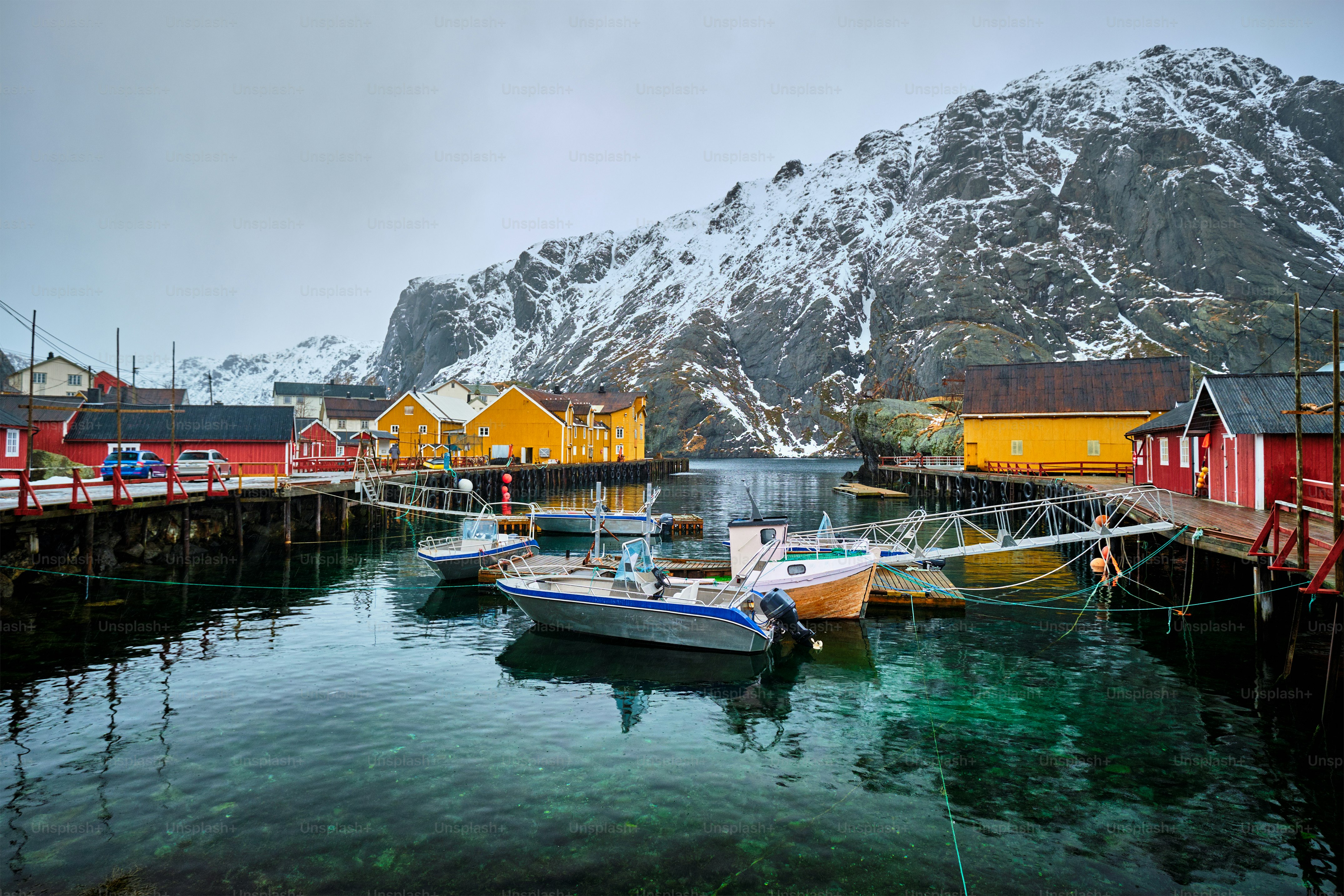 Pier mit Booten in Nusfjord authentisches Fischerdorf im Winter mit roten Rorbu-Häusern. Lofoten, Norwegen