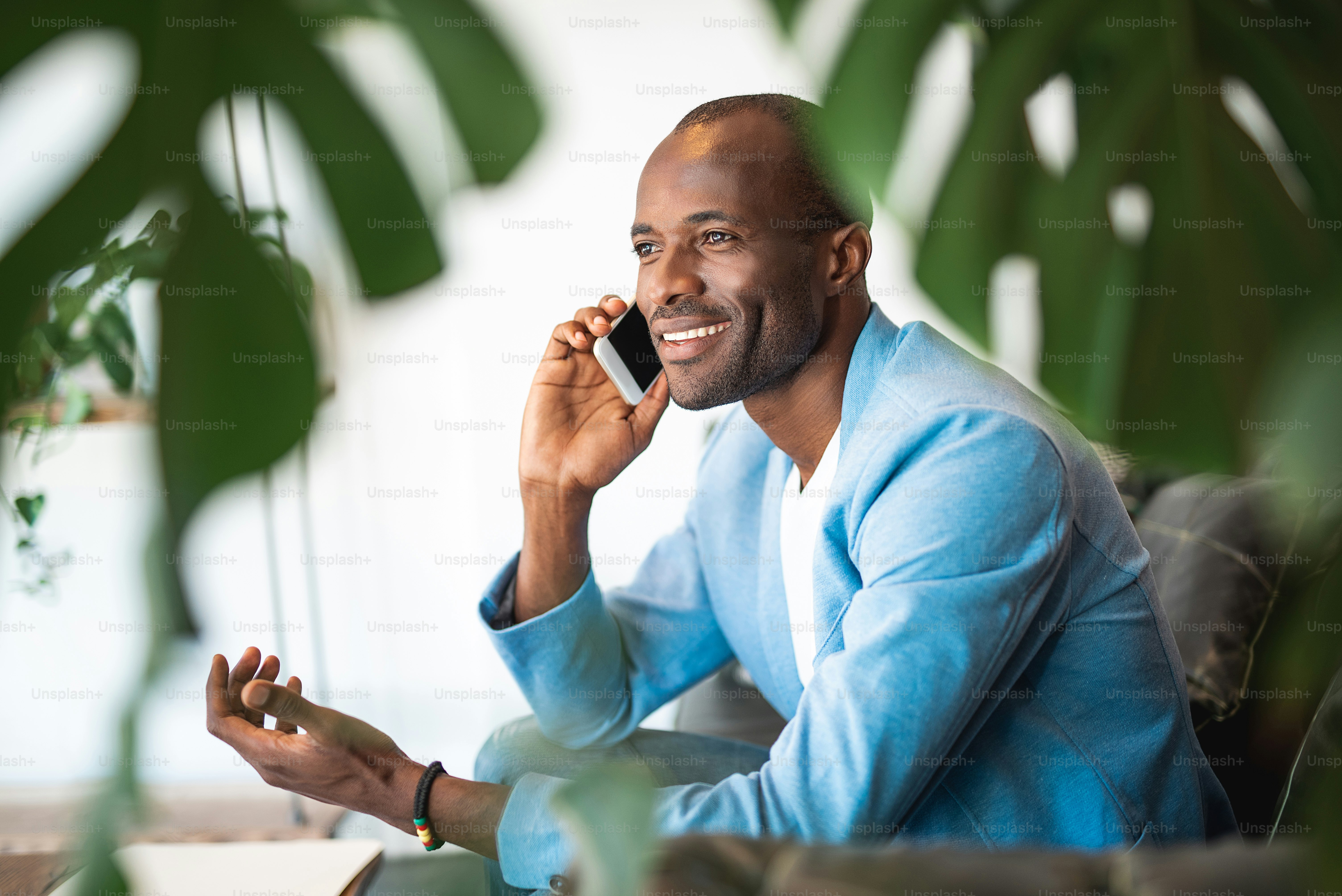 Portrait of beaming male telling by mobile while gesticulating hand ...