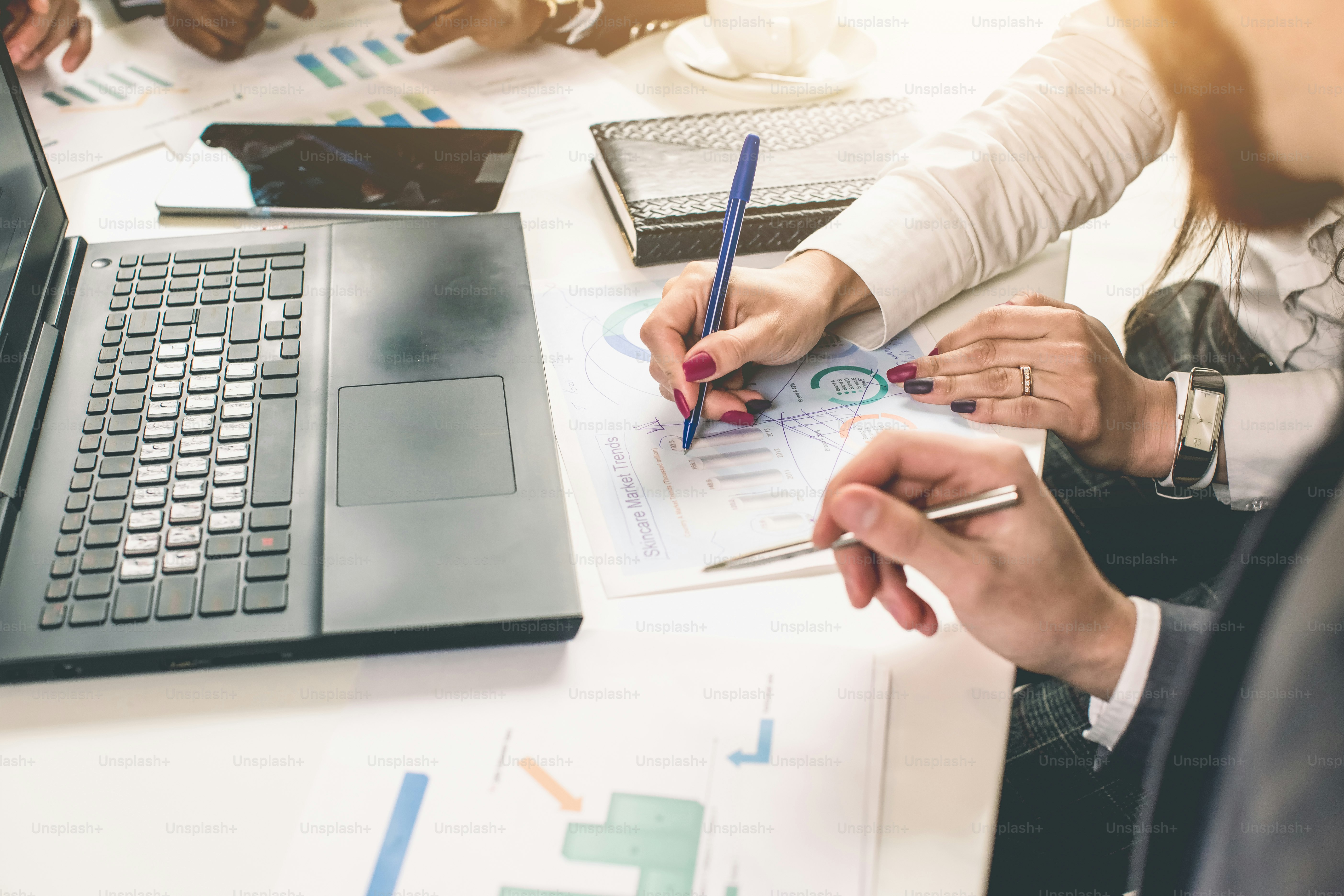 Professionnels du monde des affaires. Groupe de jeunes gens d’affaires confiants qui analysent des données à l’aide d’un ordinateur tout en passant du temps au bureau