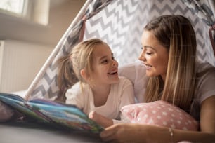 Great story. Mother and daughter in bed reading book.