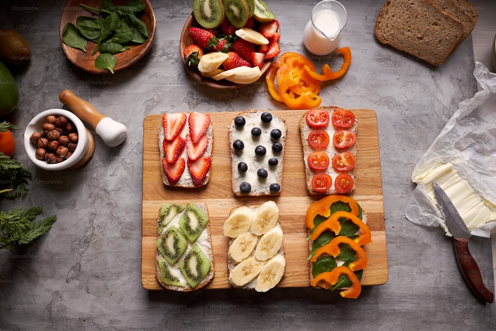 Top view of table with wooden cutting board and healthy sandwiches