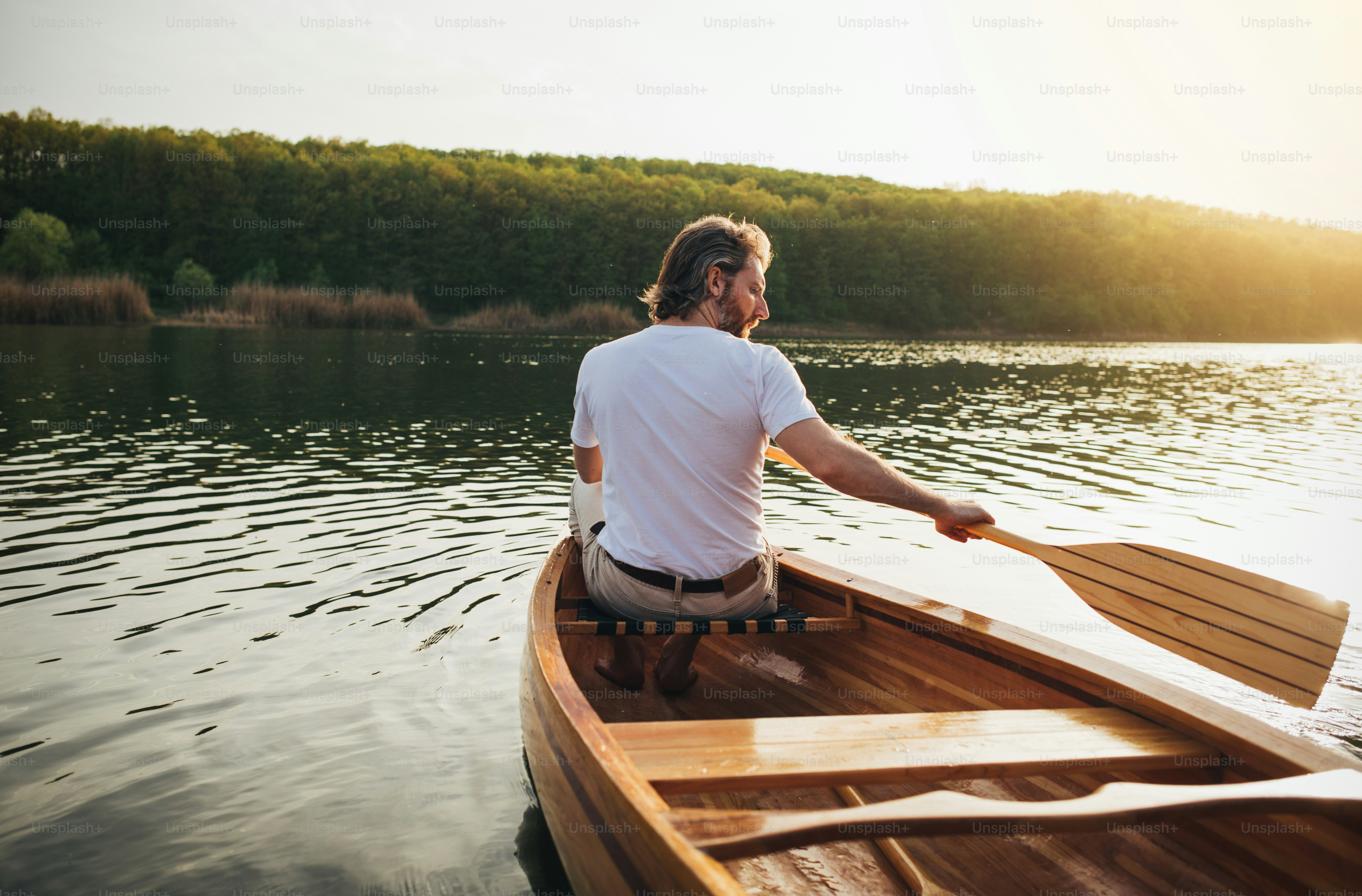 Rear View Of Male Canoeist Paddling The Wooden Canoe With Oar. Photo ...