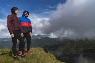 The man and woman standing on a mountain with a beautiful view