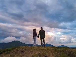 The woman and man standing on the mountain