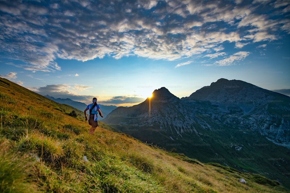 Skyrunner runner runs in the mountains as the sun rises