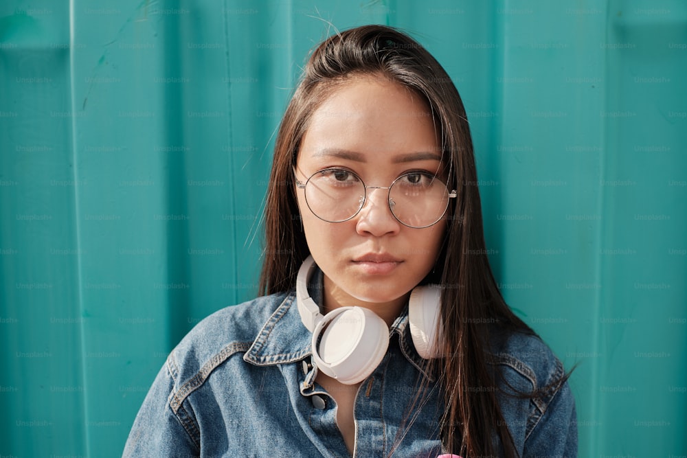 Retrato de una chica asiática con gafas y mirando directamente a la cámara.