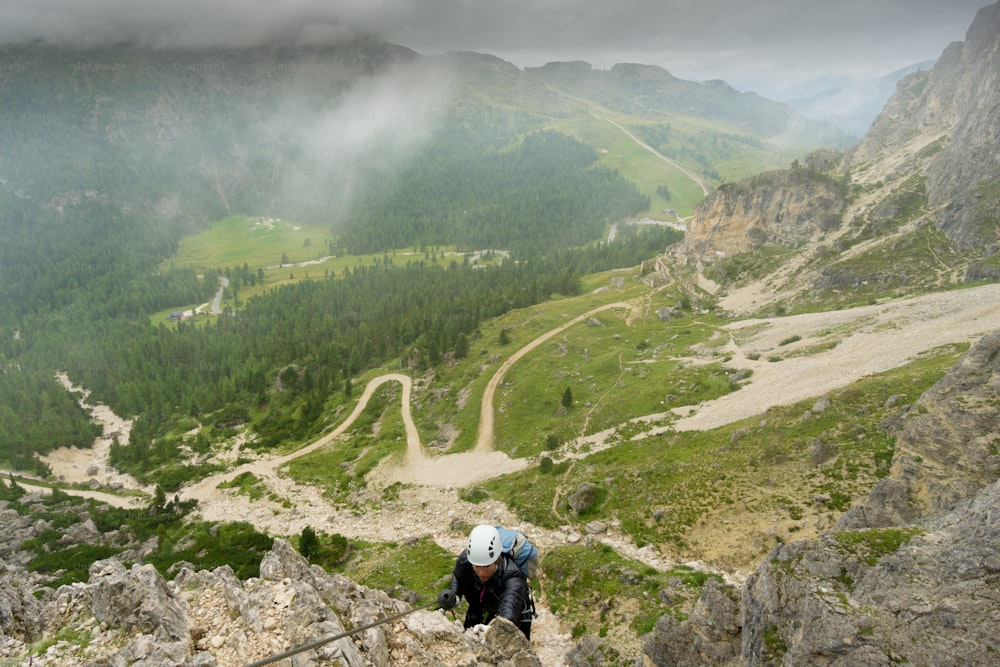 atraente jovem alpinista feminino em uma Via Ferrata nas Dolomitas da Itália em mau tempo