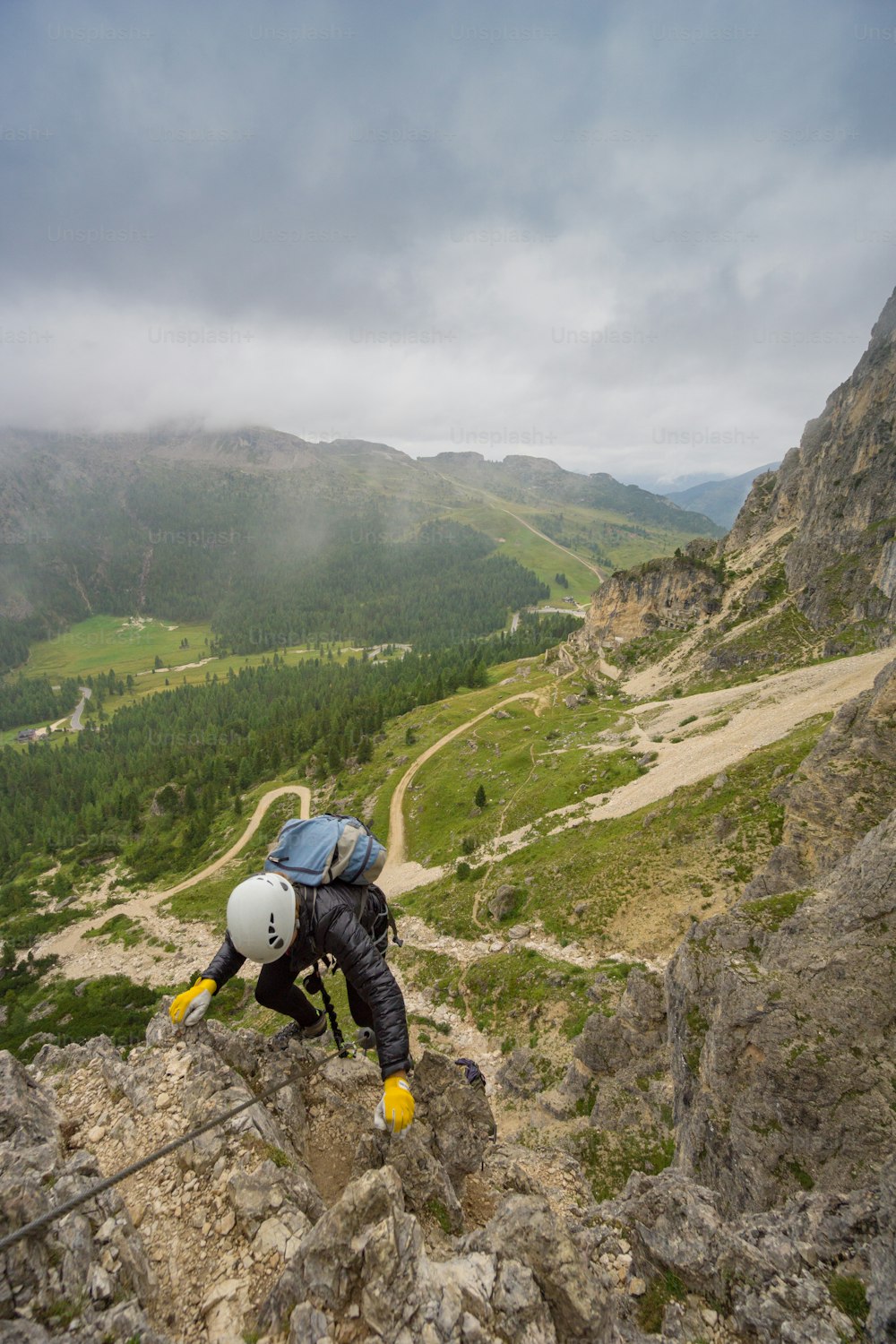 atraente jovem alpinista feminino em uma Via Ferrata nas Dolomitas da Itália em mau tempo