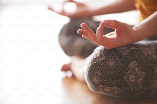 Primer plano en el enfoque selectivo del mudra de gestos de las manos femeninas, mientras se hace yoga vinyasa flow, Padmasana, estado mental de nirvana
