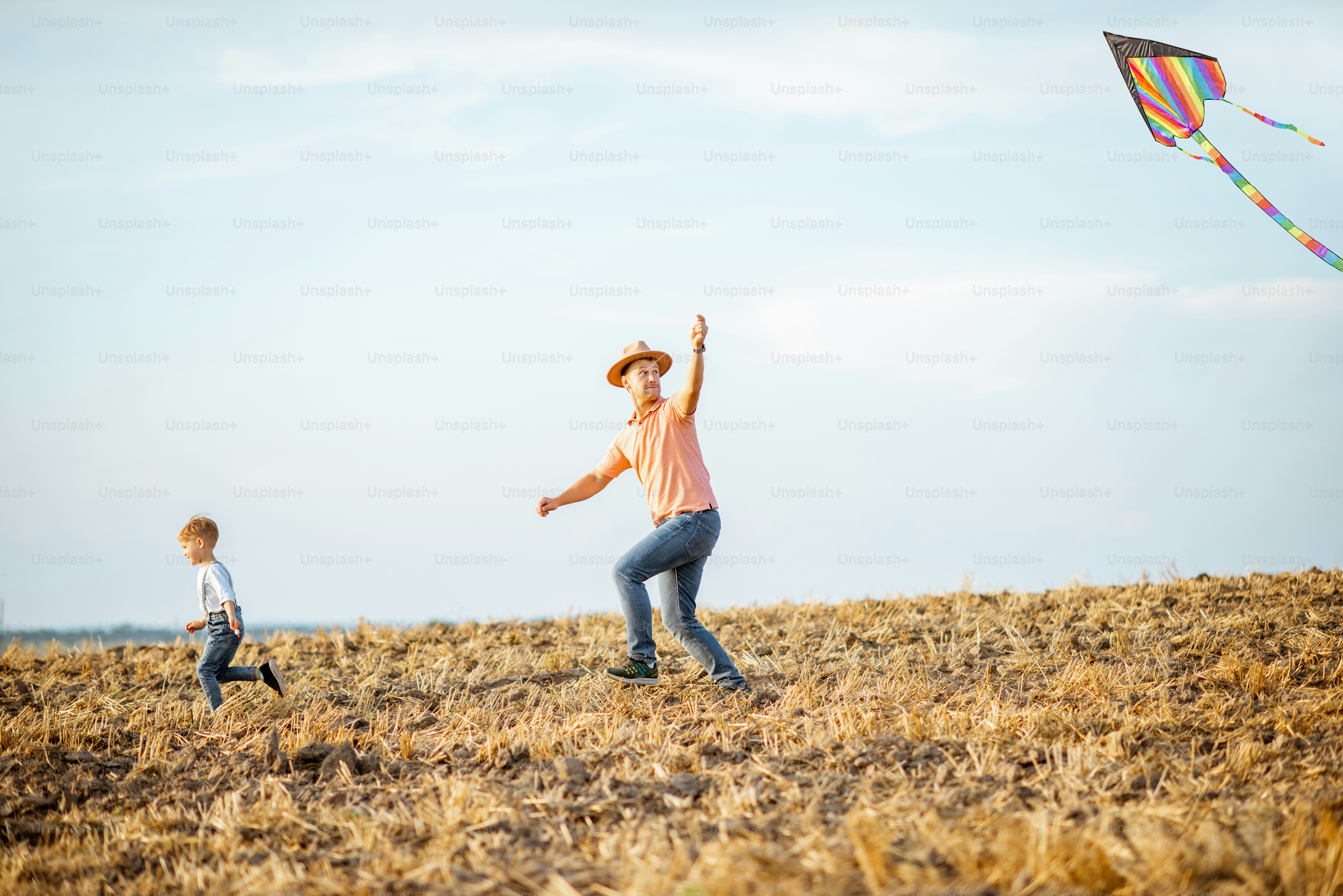 Father with son launching colorful air kite on the field. Concept of a ...