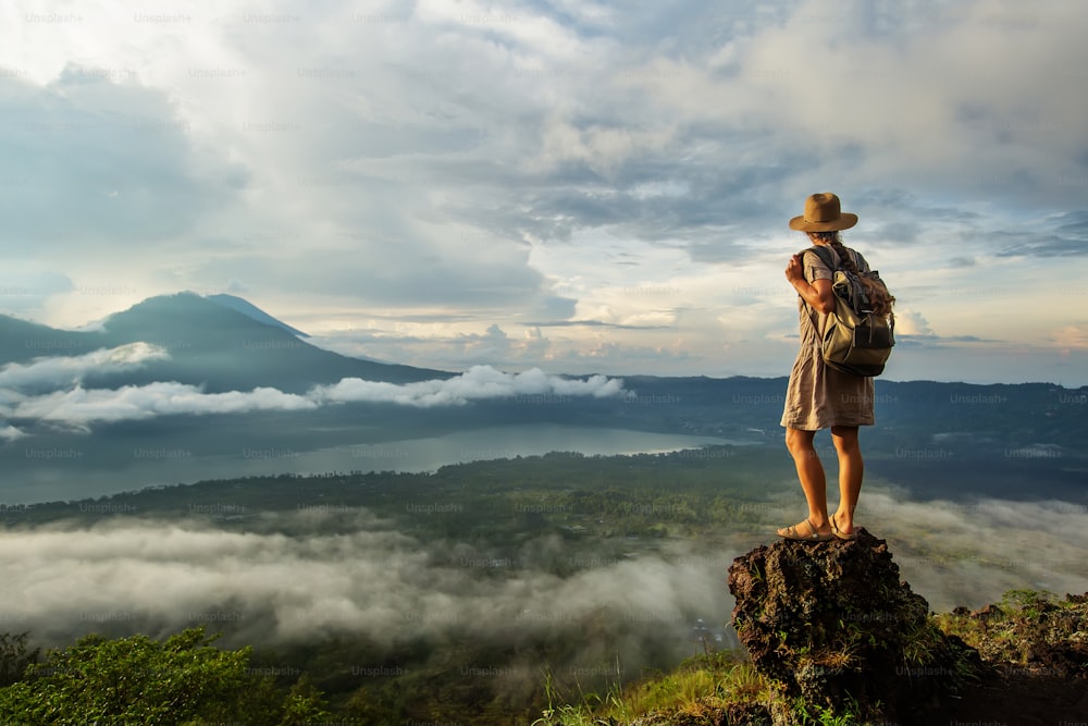 インドネシア、バリ島、バトゥール山の頂上から日の出を楽しむ女性。