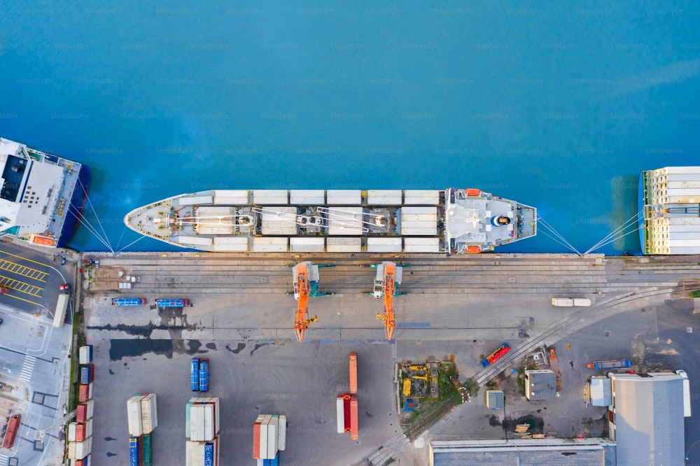 港の桟橋に係留された巨大な貨物船を空中から見下ろし、貨物・コンテナ貨物を積み込む