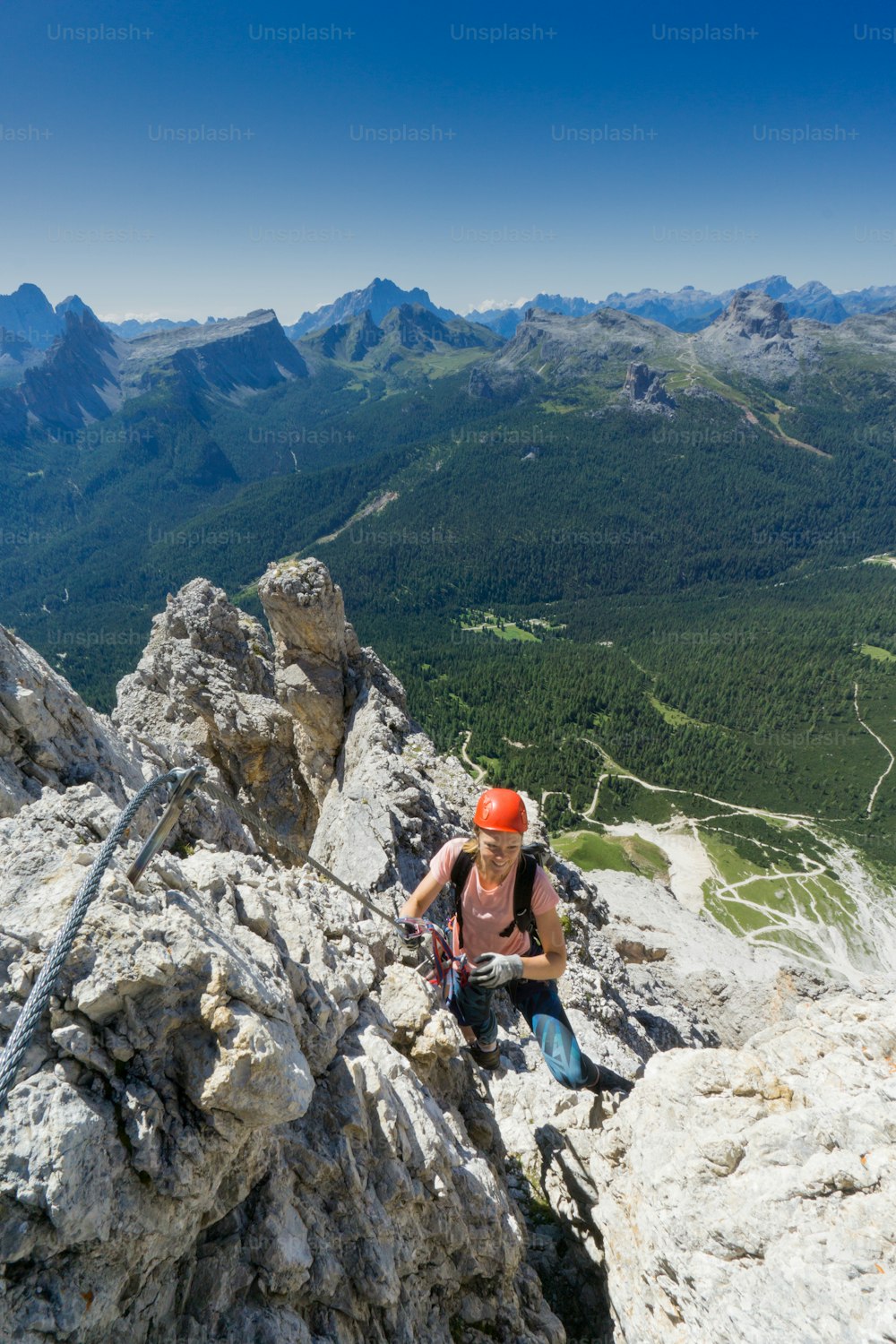 attractive brunette female mountain climber on a steep Via Ferrata in the South Tyrol