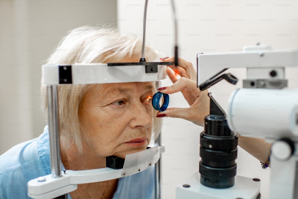 Mulher idosa durante um exame oftalmológico médico com microscópio no consultório oftalmológico