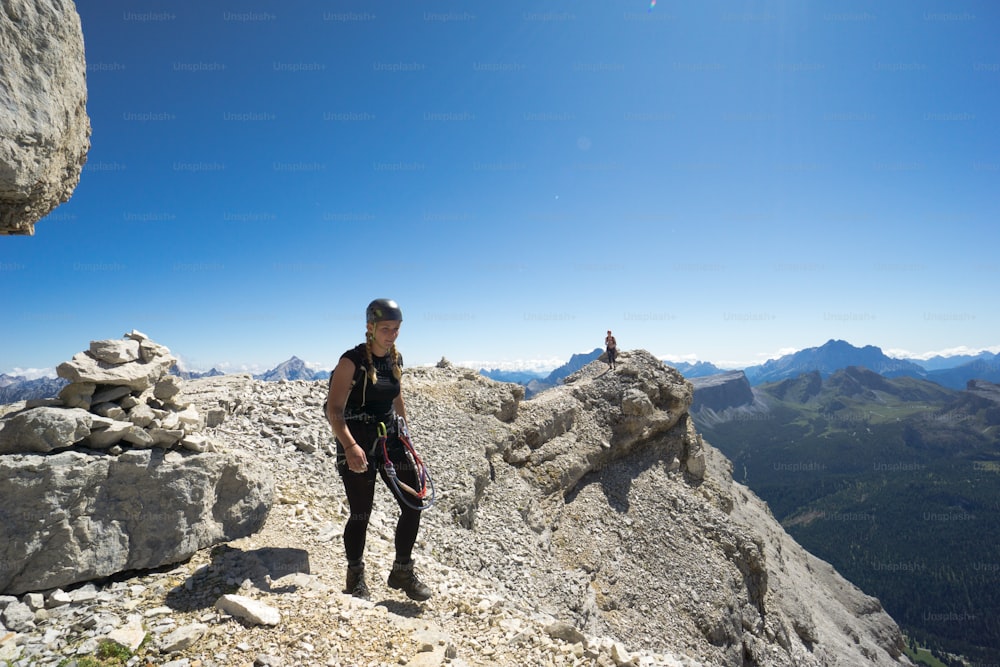 woman climbers hiking along a rocky summit ridge in the Dolomites of Italy after exiting a climbing route