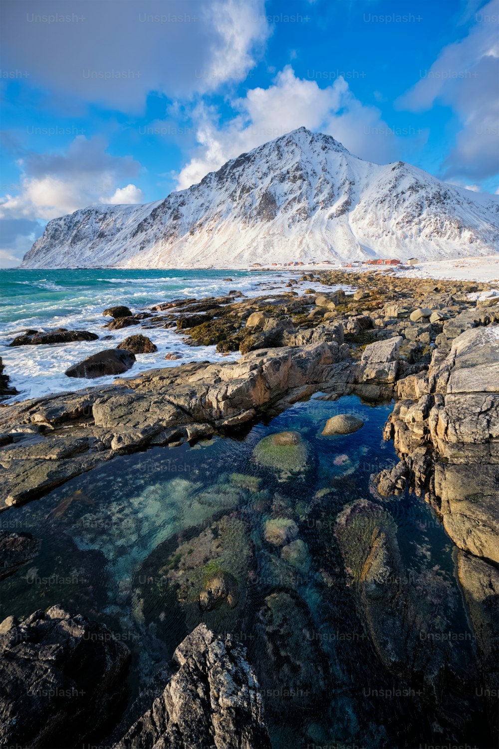 冬の夕暮れ時のフィヨルドの岩だらけの海岸にあるノルウェーの海のビーチ。ヴァレイド ビーチ、ロフォーテン諸島、ノルウェー