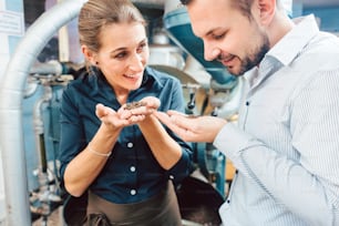 Man and woman with freshly roasted coffee enjoying the aroma