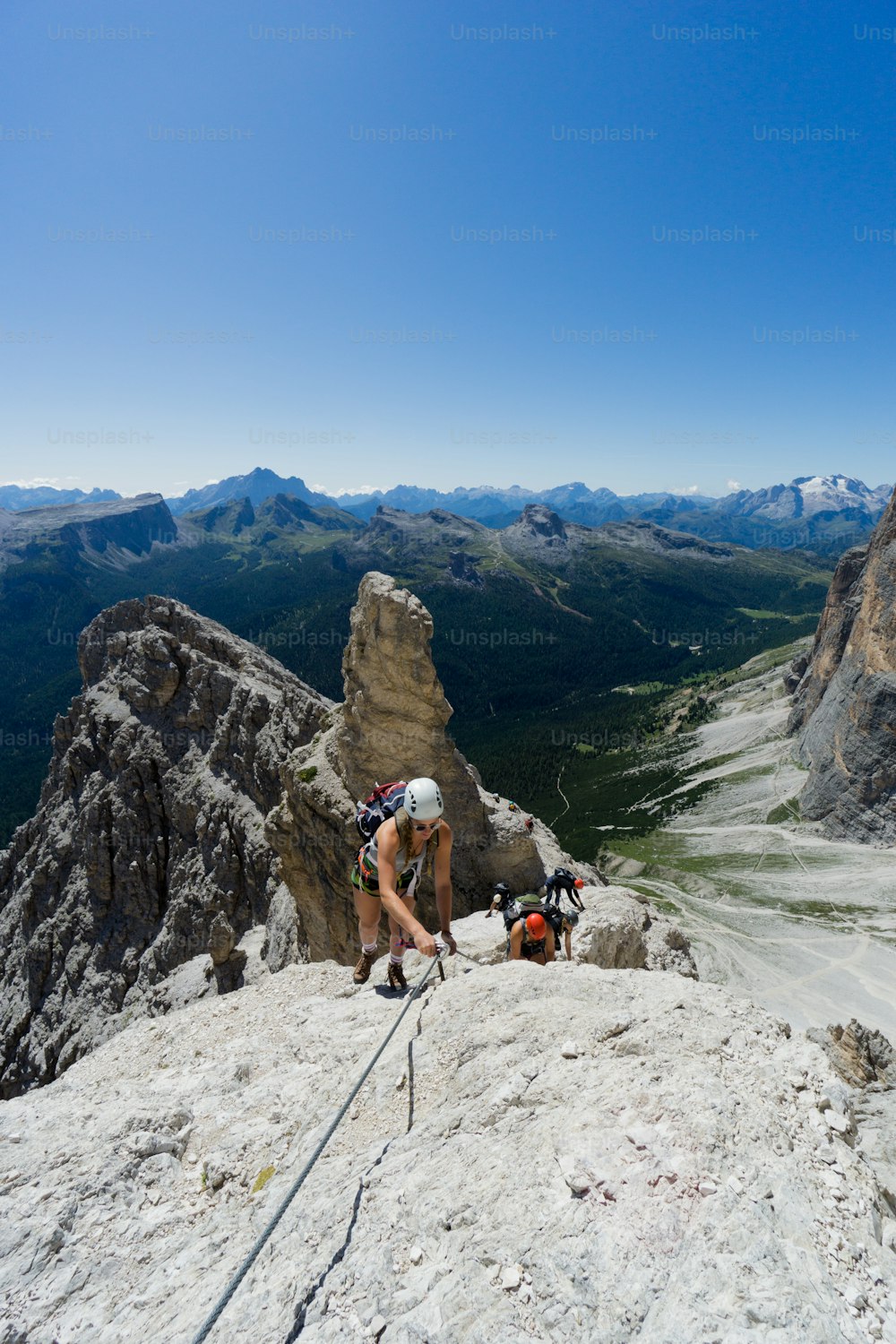 group of mountain climbers on a steep Via Ferrata with a grandiose view of the Italian Dolomites