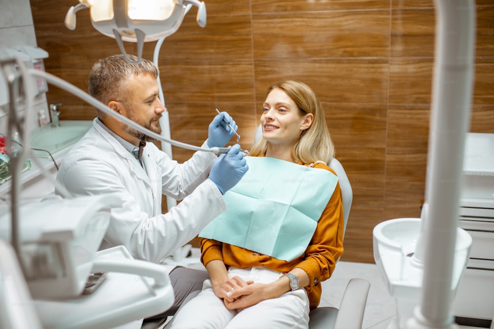 Beautiful woman as a patient during a teeth inspection with a senior experienced dentist at the clinic