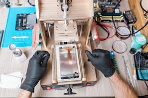 Überblick über behandschuhte Hände eines professionellen Reparateurs, der während seiner Arbeit Geräte für die Reparatur von Geräten verwendet