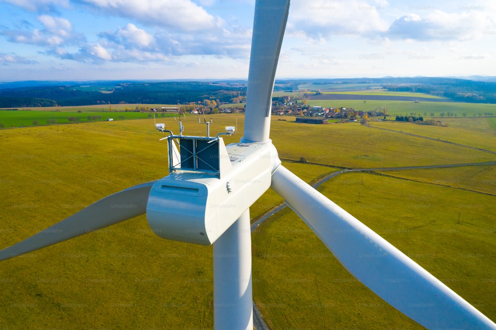 気候変動の比喩表現としての嵐の空を背景にした風力タービン。ランドスケープの発電所。持続可能な開発と電力のテーマ。風車への航空写真。